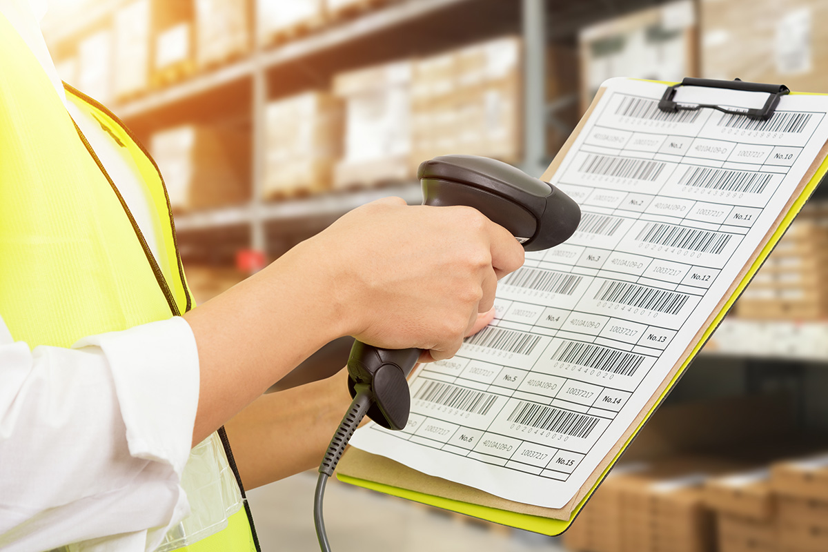 Worker checking and scanning package by laser barcode scanner in